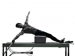 Black and white photo of male on pilates reformer