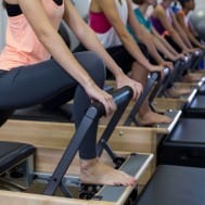 Group of women using Pilates reformers